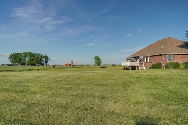 view of yard with a wooden deck and a rural view