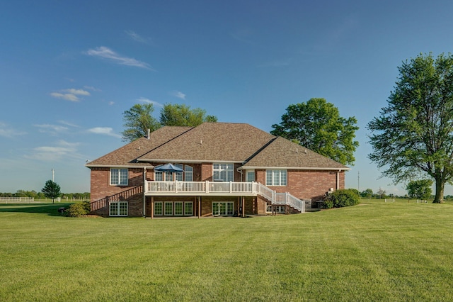 back of property with a deck and a lawn