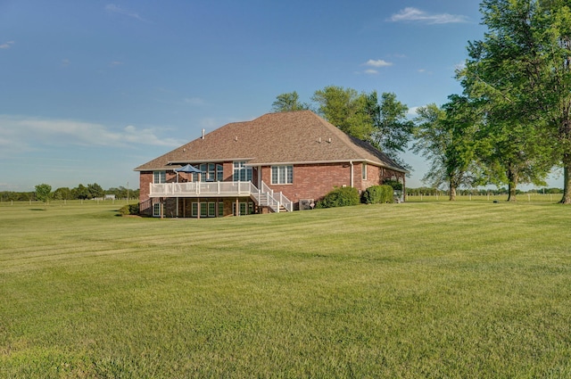 rear view of property with a yard and a deck