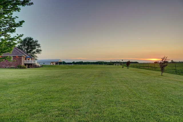 yard at dusk featuring a rural view