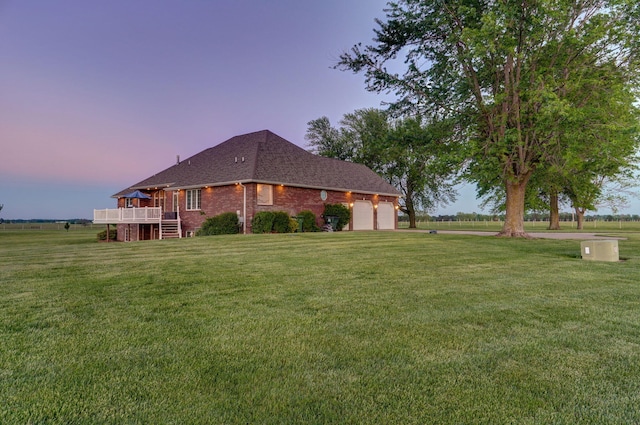 property exterior at dusk featuring a garage, a deck, and a lawn