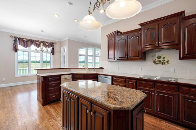 kitchen with stovetop, a center island, sink, and a wealth of natural light