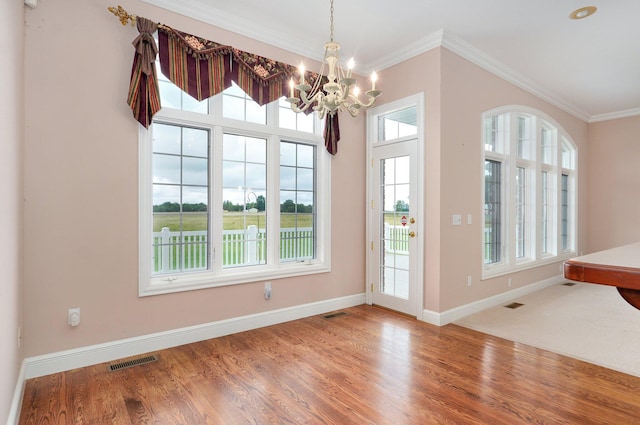 interior space featuring ornamental molding, hardwood / wood-style flooring, and a notable chandelier