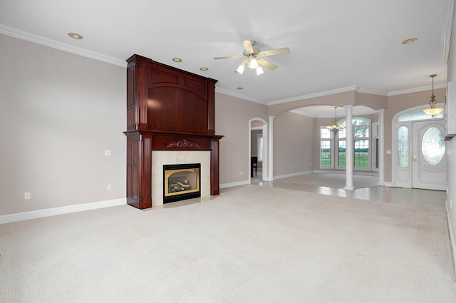 unfurnished living room with light carpet, crown molding, decorative columns, and a large fireplace