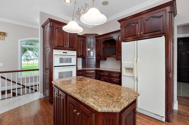 kitchen with pendant lighting, ornamental molding, white appliances, dark wood-type flooring, and a center island