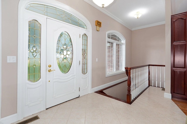 tiled foyer entrance featuring crown molding