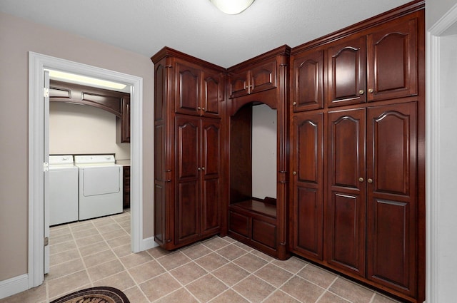 kitchen with washing machine and clothes dryer, light tile patterned floors, and a textured ceiling