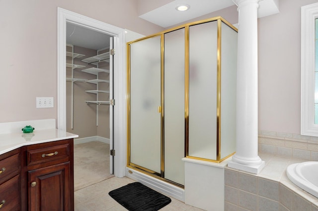 bathroom featuring plus walk in shower, tile patterned floors, decorative columns, and vanity