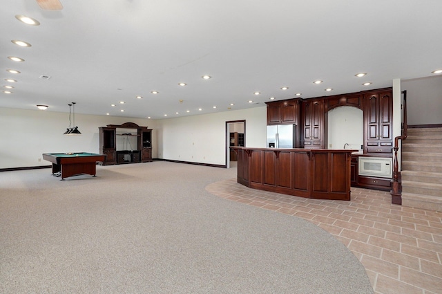 interior space featuring pendant lighting, stainless steel refrigerator with ice dispenser, a center island, and billiards