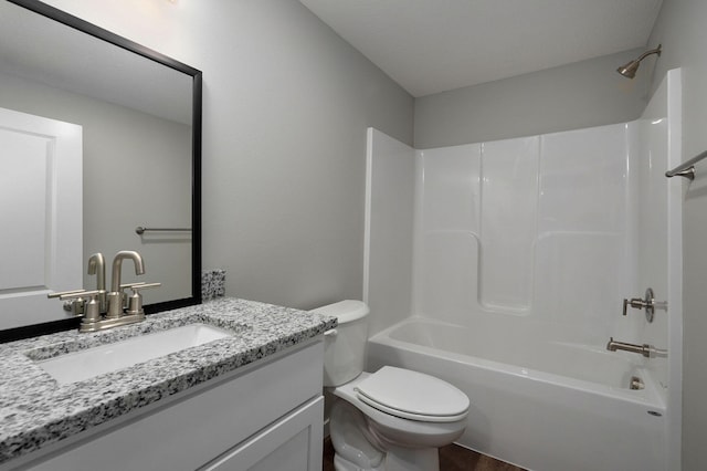 full bathroom featuring vanity, bathtub / shower combination, toilet, and a textured ceiling