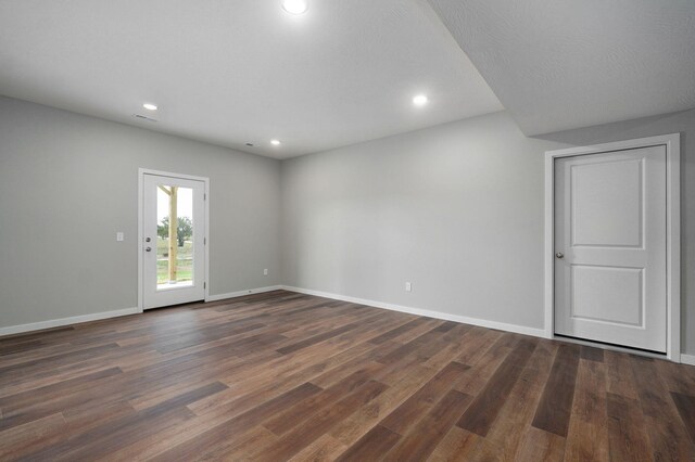 spare room featuring dark hardwood / wood-style floors and a textured ceiling