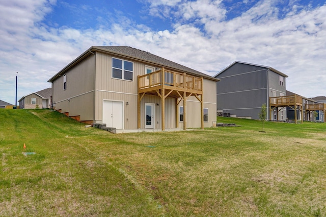 rear view of house featuring a yard and a deck