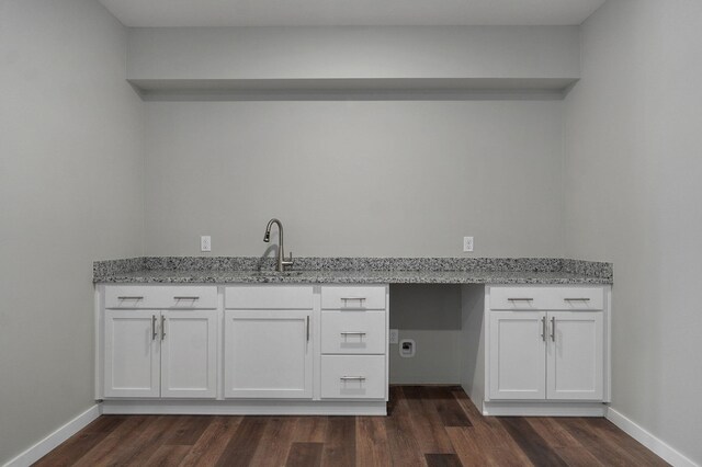 interior space featuring light stone counters, white cabinets, sink, and dark hardwood / wood-style flooring