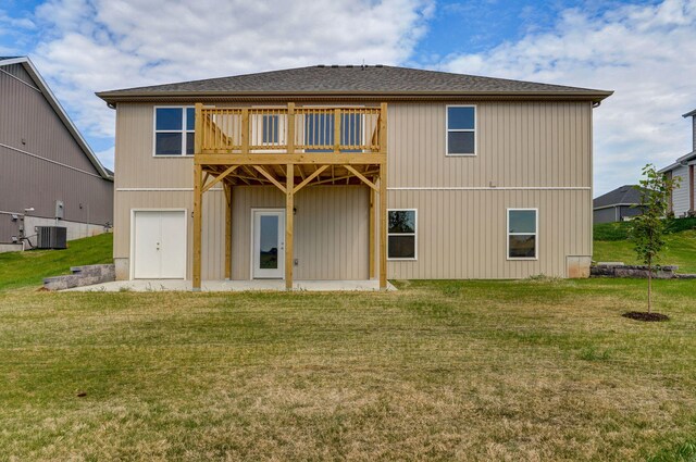 back of house featuring a yard, a balcony, and central AC unit