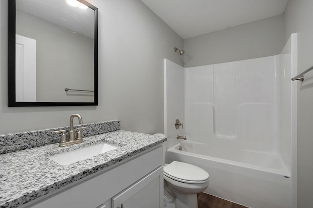 full bathroom featuring wood-type flooring, tub / shower combination, vanity, and toilet