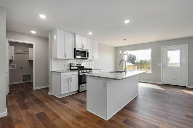 kitchen with white cabinets, stainless steel appliances, hanging light fixtures, and sink