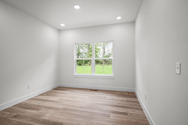 empty room featuring recessed lighting, light wood-style flooring, visible vents, and baseboards