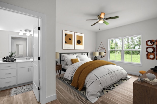 bedroom with light hardwood / wood-style floors, sink, and ceiling fan