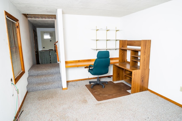 carpeted office space featuring a textured ceiling