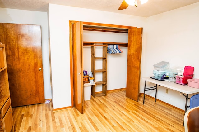 bedroom with light wood-type flooring, ceiling fan, a closet, and a textured ceiling