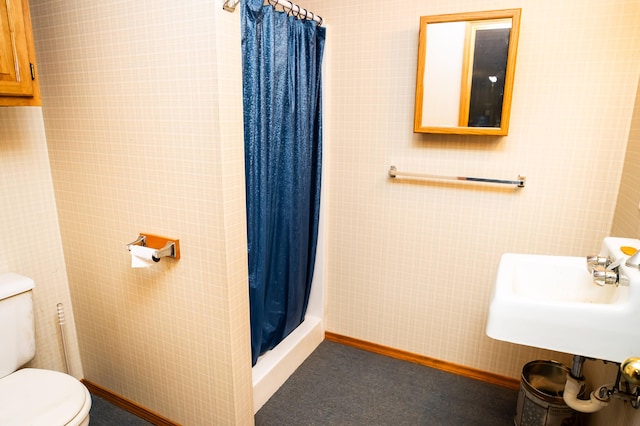 bathroom featuring sink, a shower with shower curtain, and toilet