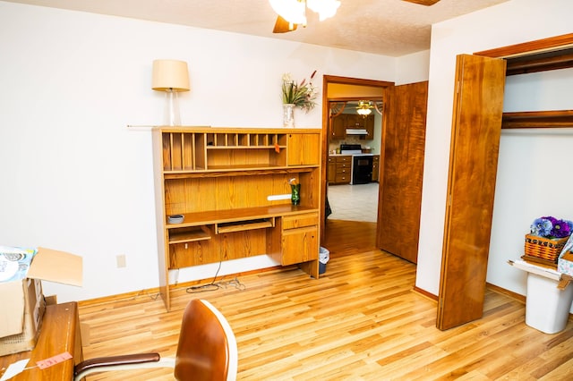 home office featuring a textured ceiling, ceiling fan, and light hardwood / wood-style flooring