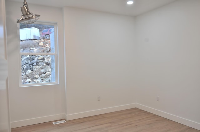 unfurnished room with a healthy amount of sunlight and light hardwood / wood-style floors