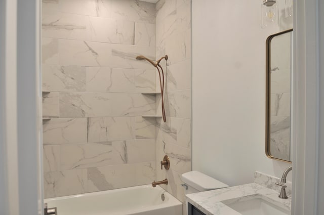 full bathroom featuring tiled shower / bath combo, vanity, and toilet