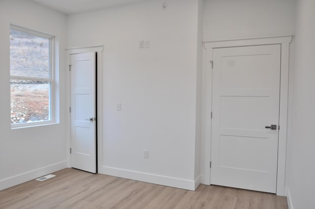 empty room featuring a healthy amount of sunlight and light wood-type flooring