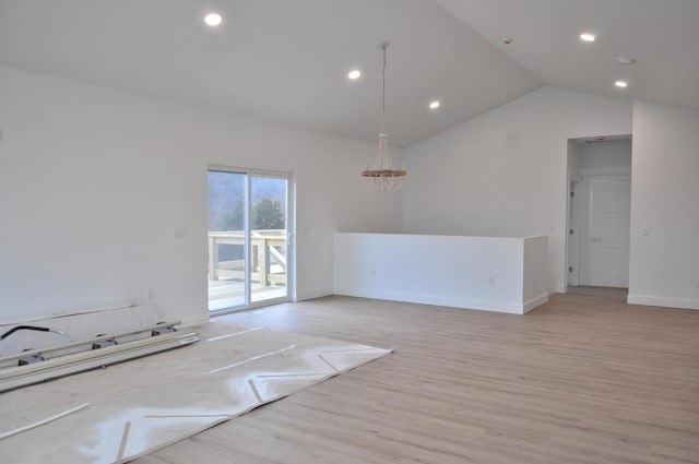 spare room featuring vaulted ceiling and light wood-type flooring