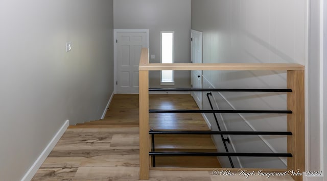 stairway with wood finished floors and baseboards