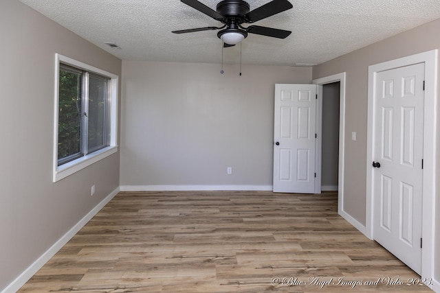 unfurnished room with light hardwood / wood-style flooring, a textured ceiling, and ceiling fan