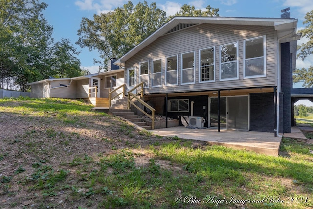 rear view of house with a patio area, ac unit, and a chimney