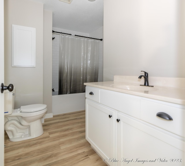 full bath featuring wood finished floors, vanity, shower / tub combo with curtain, toilet, and visible vents
