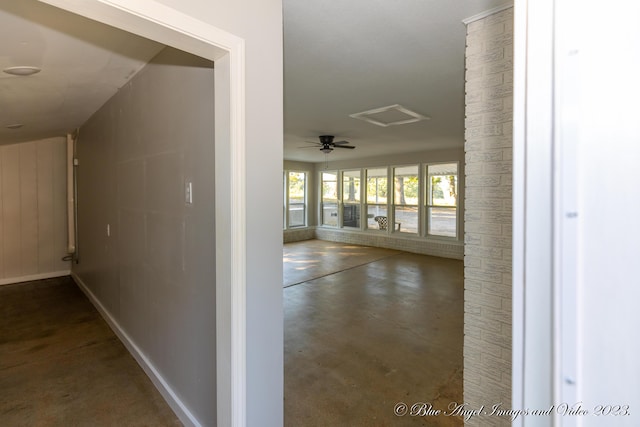 hallway with baseboards and concrete floors