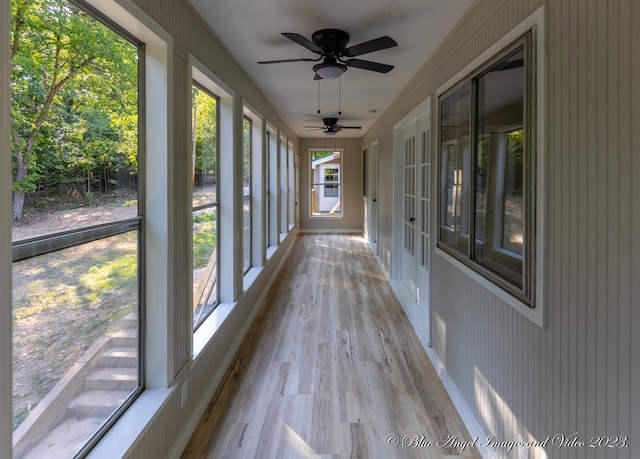 unfurnished sunroom with ceiling fan