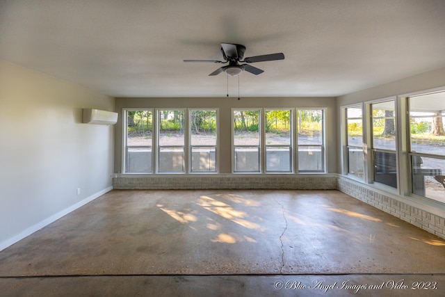 unfurnished sunroom featuring a wall unit AC, a wealth of natural light, and ceiling fan