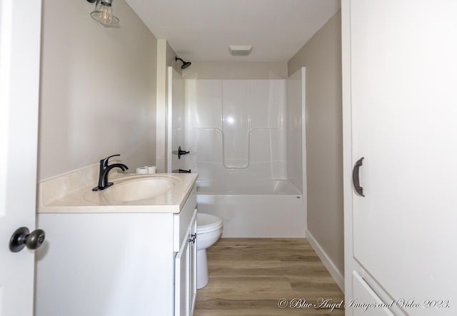 full bathroom with  shower combination, vanity, hardwood / wood-style floors, and toilet