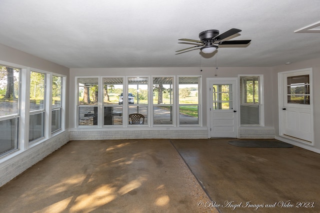 unfurnished sunroom featuring ceiling fan