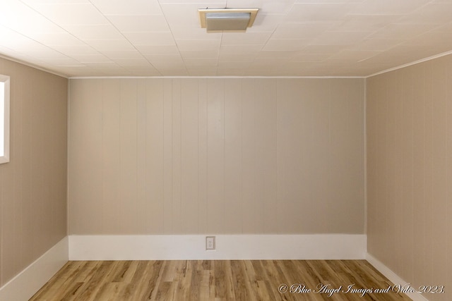 spare room featuring wood walls and wood-type flooring