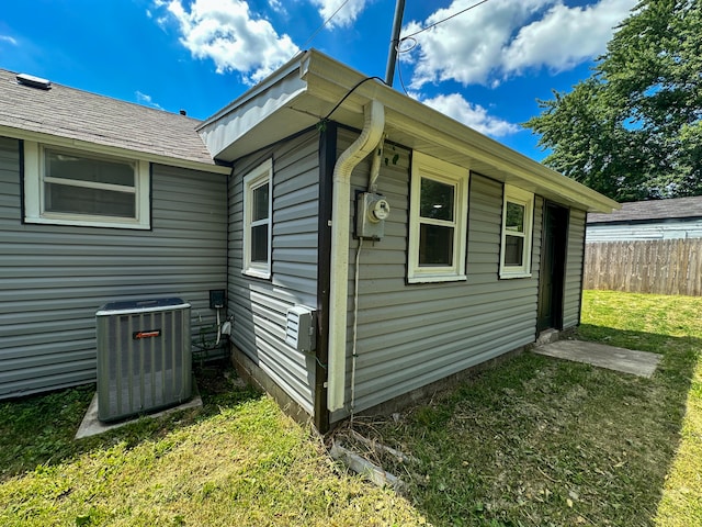 view of side of property featuring a yard and cooling unit