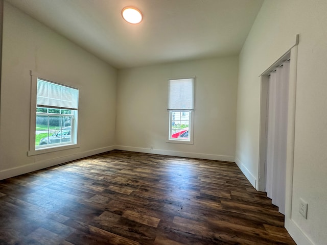 unfurnished room with dark wood-type flooring