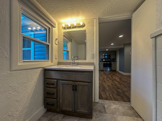 bathroom featuring hardwood / wood-style flooring, vanity, and a textured ceiling