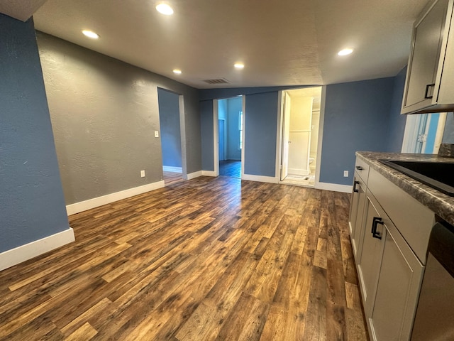 kitchen with gray cabinets, sink, dark hardwood / wood-style flooring, and stainless steel dishwasher