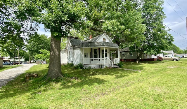 view of side of home with a yard and a porch