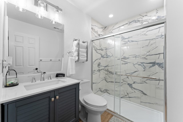 bathroom with vanity, toilet, and a shower with door