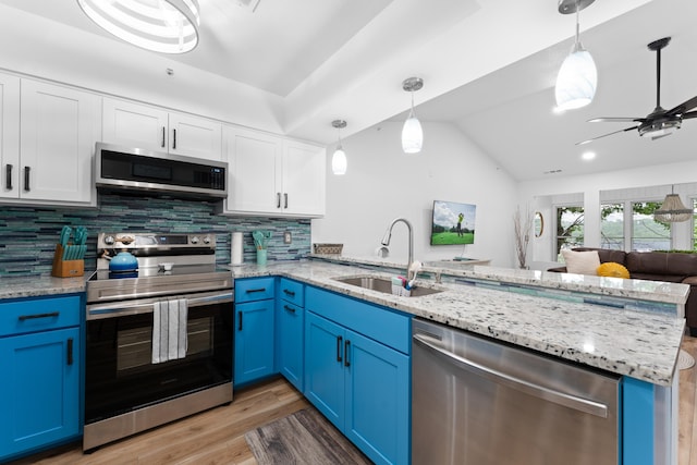 kitchen featuring blue cabinetry, decorative light fixtures, appliances with stainless steel finishes, and sink