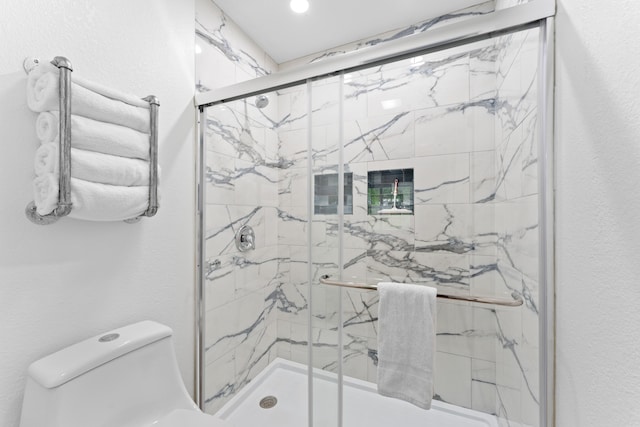 bathroom featuring an enclosed shower and toilet