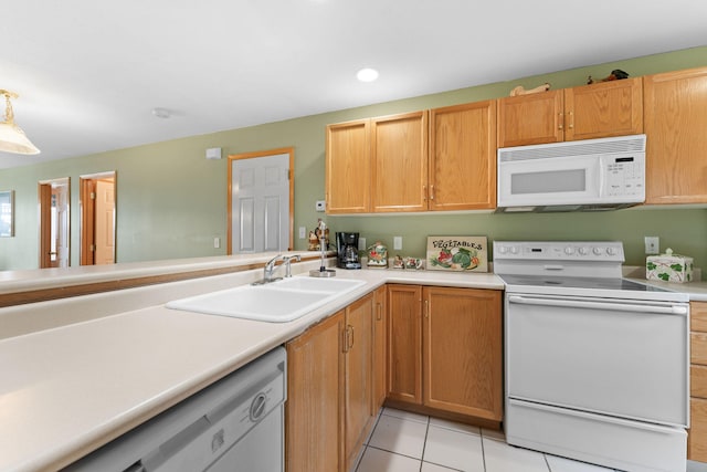 kitchen featuring light tile patterned flooring, white appliances, sink, and kitchen peninsula