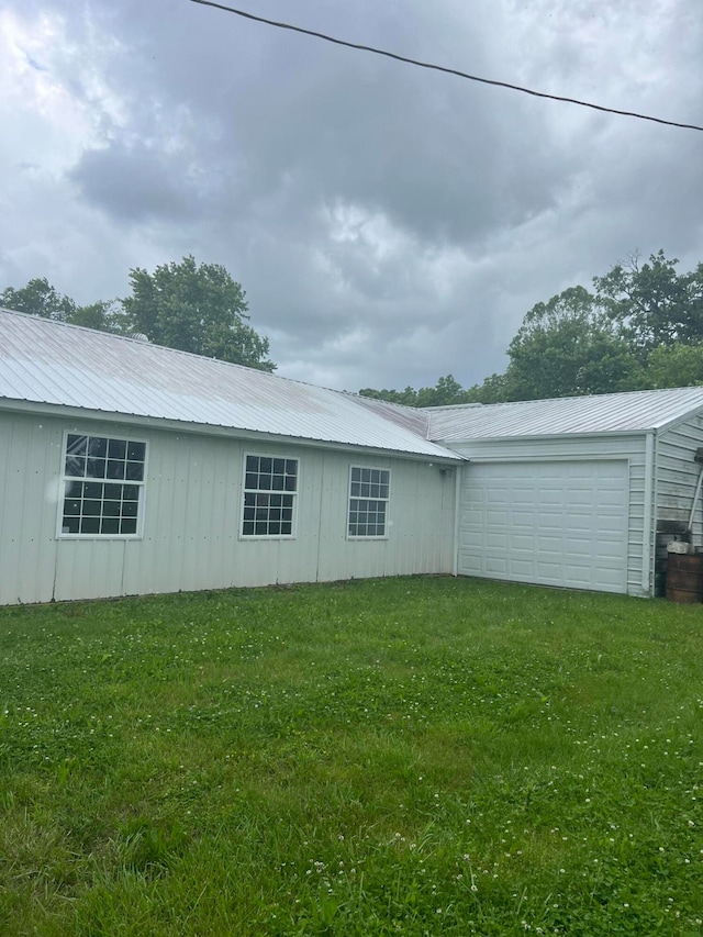 view of side of home featuring a yard and a garage